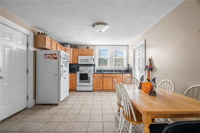 kitchen with sink, light tile patterned floors, backsplash, and white appliances