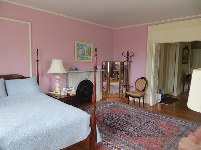 bedroom with ornamental molding and dark hardwood / wood-style floors