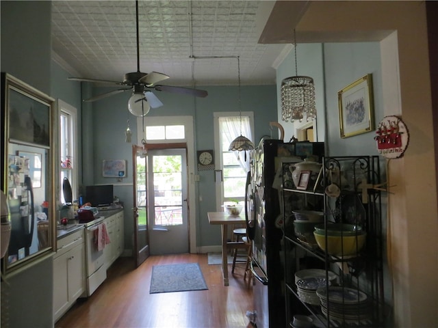 kitchen featuring white range, pendant lighting, white cabinets, light hardwood / wood-style floors, and ceiling fan