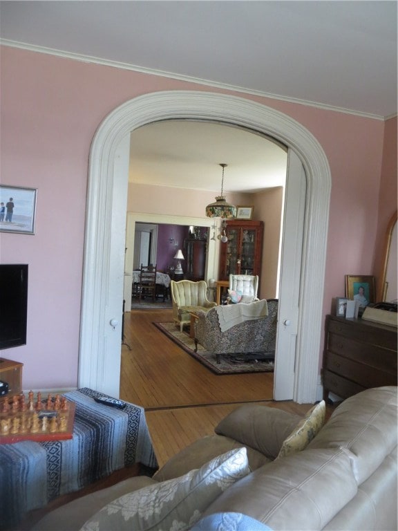 living room with crown molding and hardwood / wood-style floors