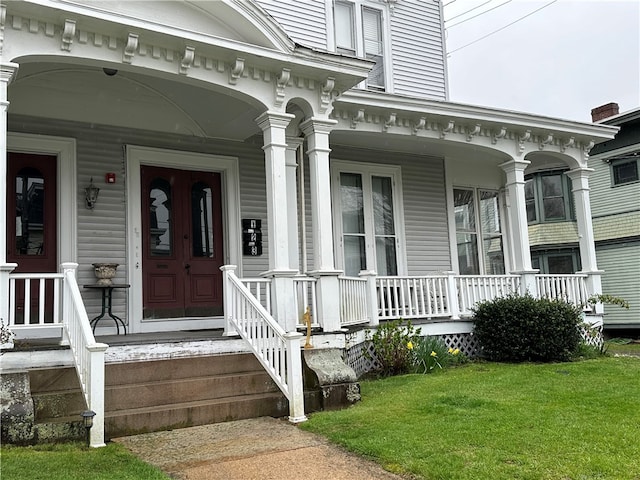 property entrance featuring a porch and a lawn