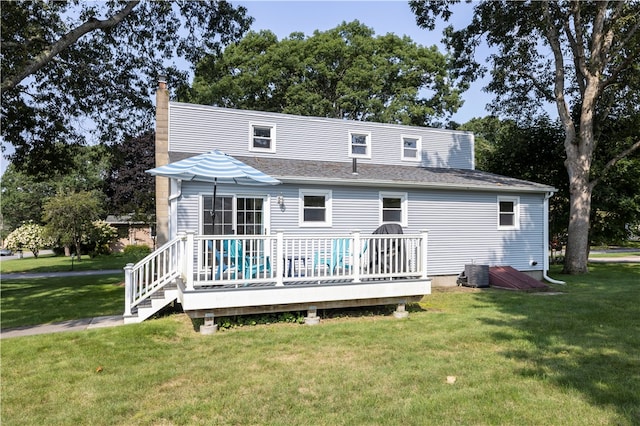 rear view of property featuring a yard, a deck, and cooling unit