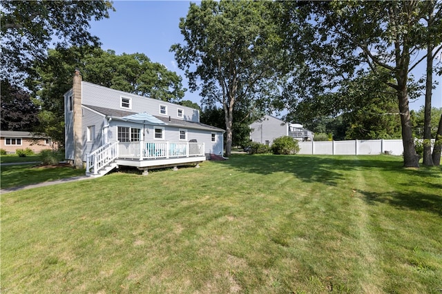 rear view of property with a wooden deck and a yard