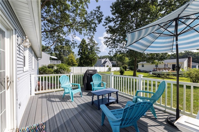 wooden deck featuring a lawn