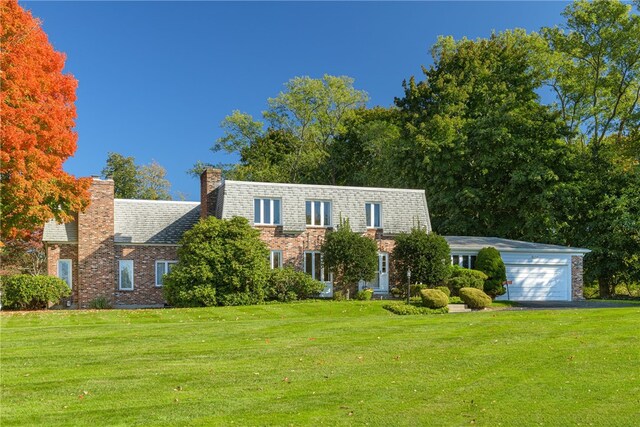 view of front of house featuring a front lawn and a garage