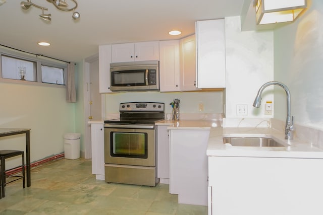 kitchen featuring appliances with stainless steel finishes, white cabinetry, and sink