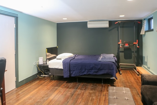 bedroom featuring an AC wall unit and hardwood / wood-style floors