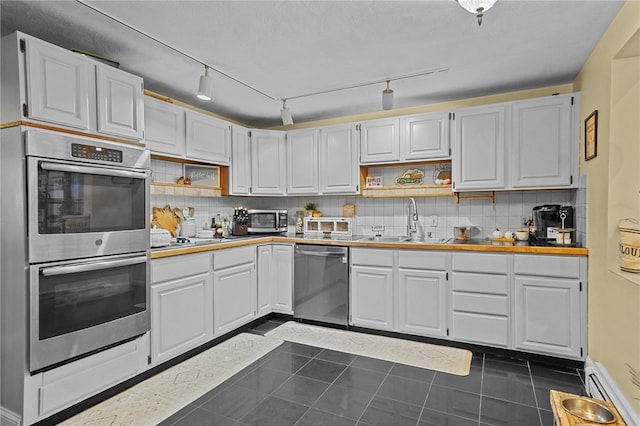 kitchen featuring white cabinetry, appliances with stainless steel finishes, sink, and decorative backsplash