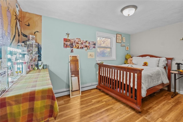 bedroom with baseboard heating and wood-type flooring