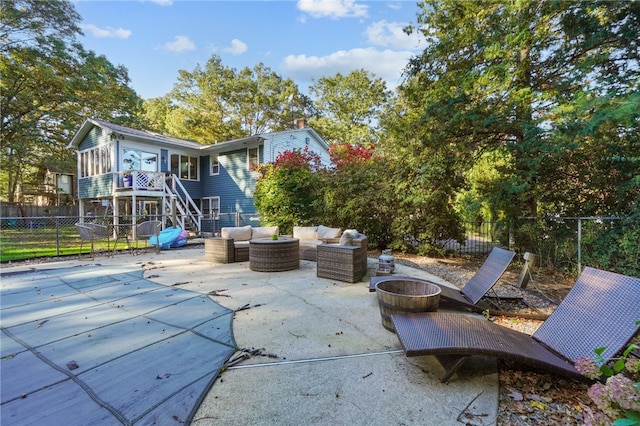 view of patio / terrace featuring an outdoor living space with a fire pit and a sunroom