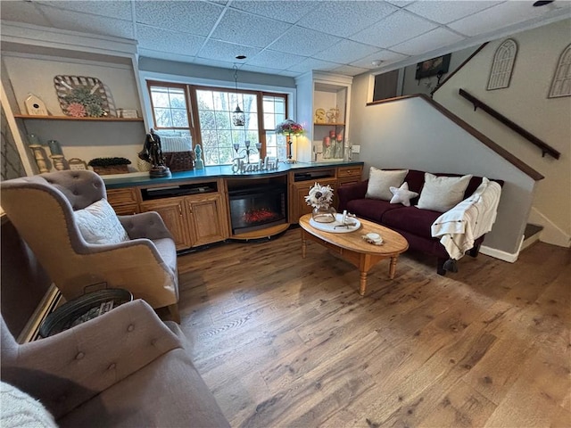 living room featuring hardwood / wood-style flooring and a drop ceiling