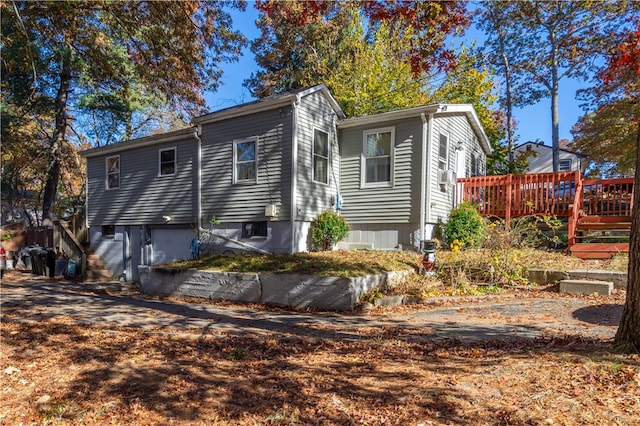 back of house featuring a garage and a deck