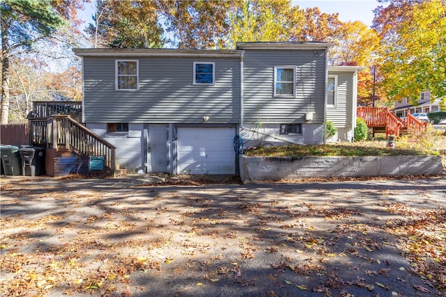 back of property with a wooden deck and a garage