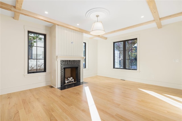 unfurnished living room featuring hardwood / wood-style flooring and beamed ceiling