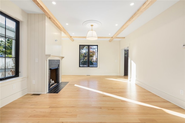 unfurnished living room with light wood-type flooring and a wealth of natural light