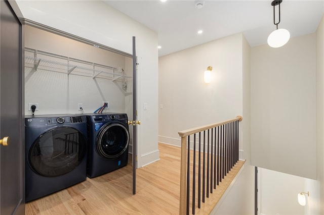 laundry room featuring light hardwood / wood-style flooring and washer and clothes dryer