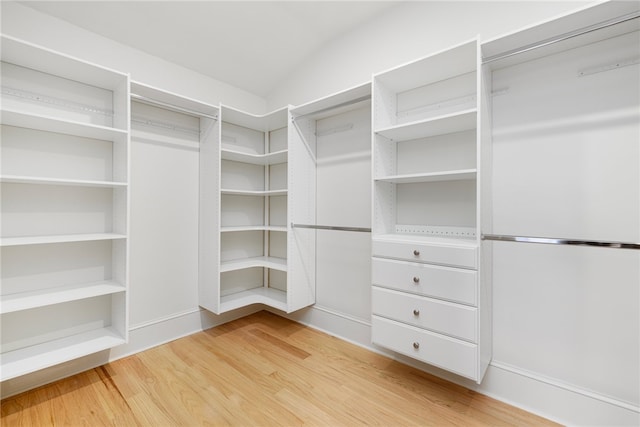 spacious closet featuring light hardwood / wood-style floors and vaulted ceiling