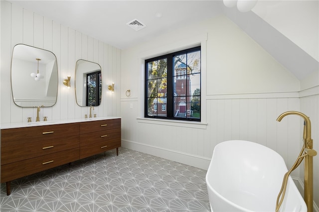 bathroom featuring vanity, lofted ceiling, a tub, and wood walls