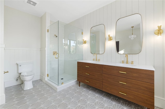 bathroom featuring vanity, toilet, a shower with shower door, and wooden walls