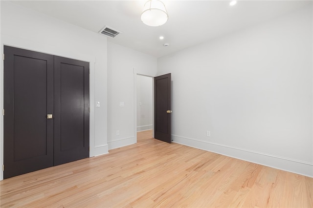 unfurnished bedroom featuring light hardwood / wood-style flooring and a closet