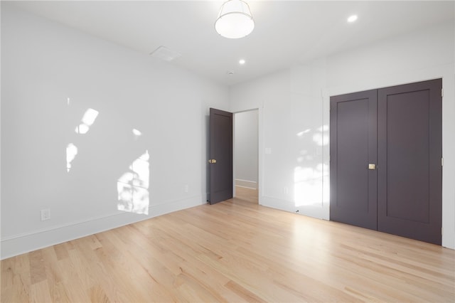 unfurnished bedroom featuring a closet and light hardwood / wood-style flooring