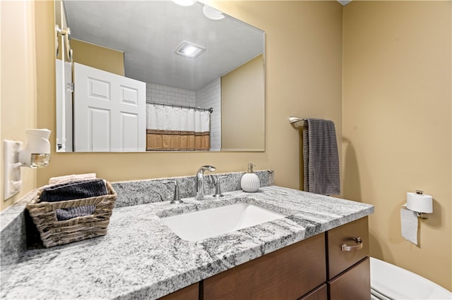 bathroom featuring vanity, curtained shower, and toilet