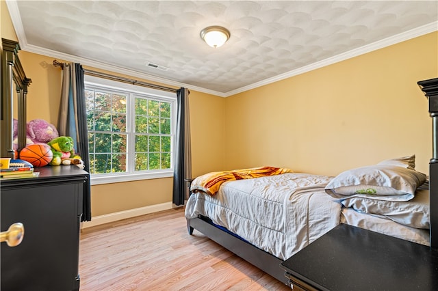 bedroom featuring light hardwood / wood-style floors and crown molding