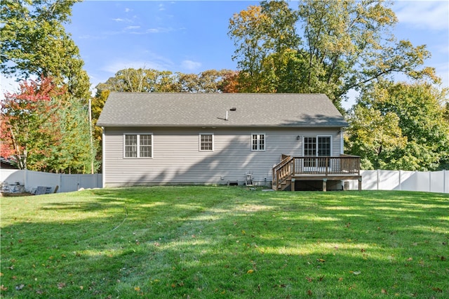 rear view of house featuring a deck and a lawn