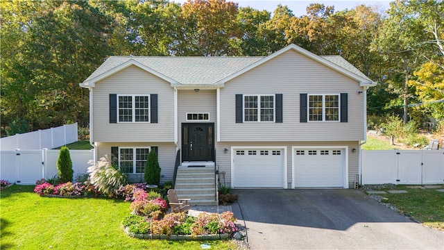 raised ranch featuring a front lawn and a garage