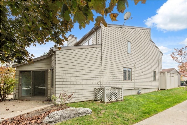 view of home's exterior with a chimney and a yard