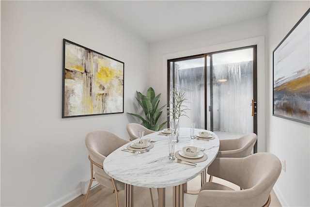 dining space featuring baseboards and wood finished floors
