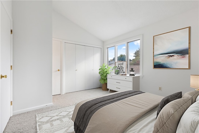 bedroom with light colored carpet, baseboards, vaulted ceiling, and a closet