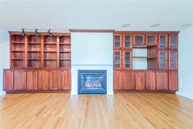 unfurnished living room featuring light hardwood / wood-style flooring and track lighting