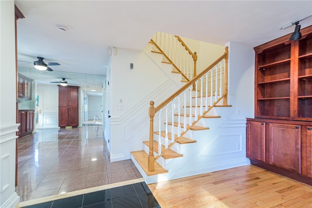 staircase featuring hardwood / wood-style flooring and ceiling fan