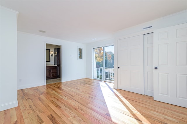 unfurnished room with ornamental molding and light wood-type flooring