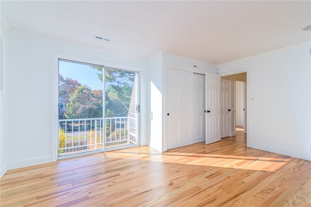 unfurnished room with a wealth of natural light, crown molding, and light hardwood / wood-style flooring