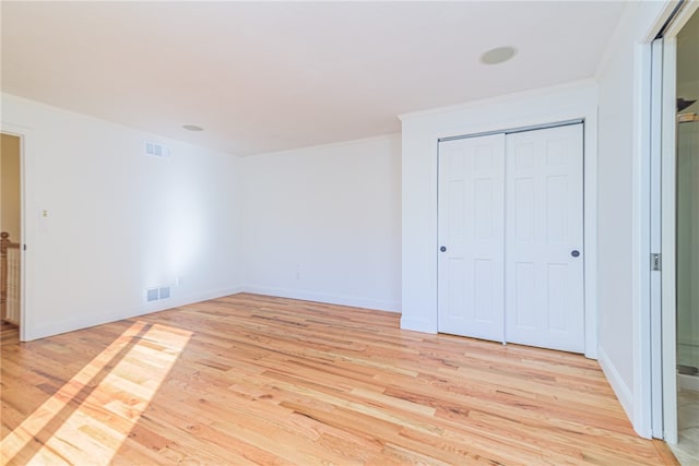 unfurnished bedroom featuring a closet and light wood-type flooring