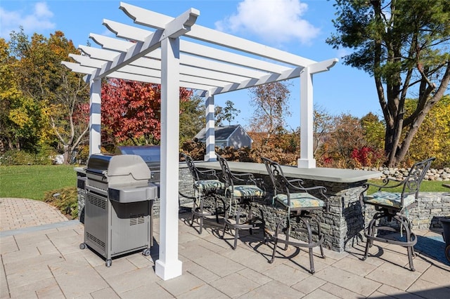 view of patio with exterior bar, a pergola, and area for grilling