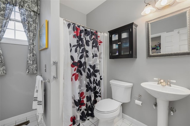 bathroom featuring toilet, sink, tile patterned flooring, and walk in shower