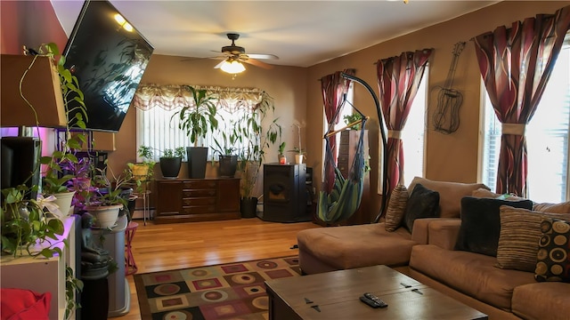 living room with light hardwood / wood-style floors, baseboard heating, and ceiling fan