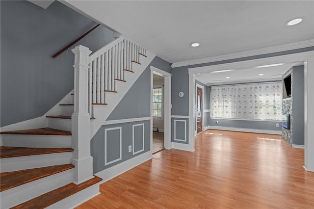 interior space with light hardwood / wood-style flooring and ornamental molding