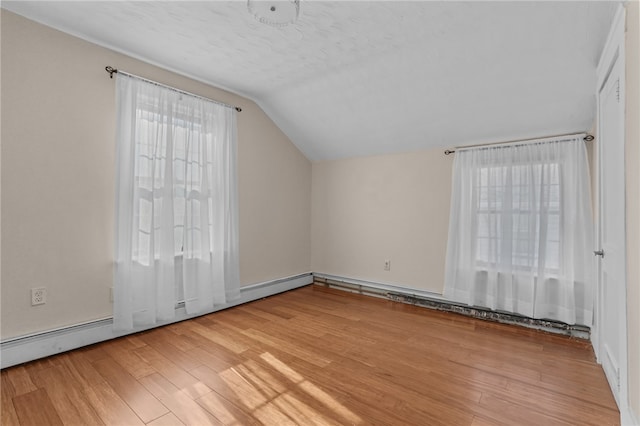 additional living space featuring lofted ceiling, a textured ceiling, and hardwood / wood-style flooring