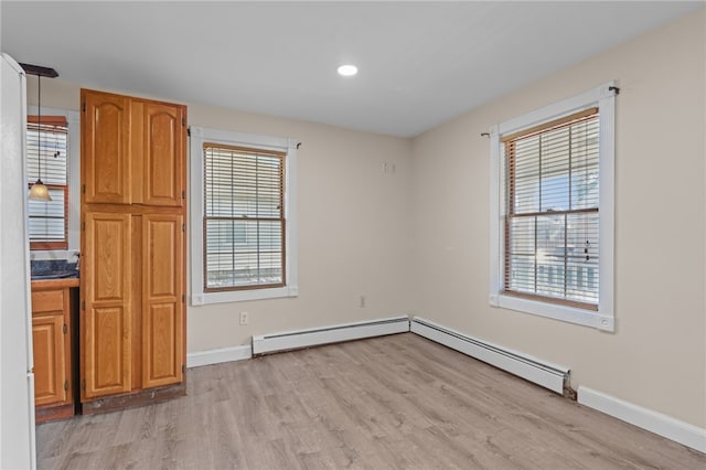 interior space with light hardwood / wood-style flooring and a baseboard heating unit