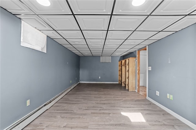 basement with baseboard heating and light wood-type flooring