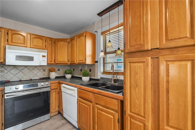 kitchen featuring light hardwood / wood-style flooring, sink, backsplash, and white appliances