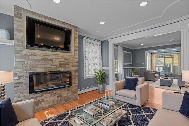 living room featuring crown molding, a stone fireplace, a baseboard heating unit, and hardwood / wood-style floors