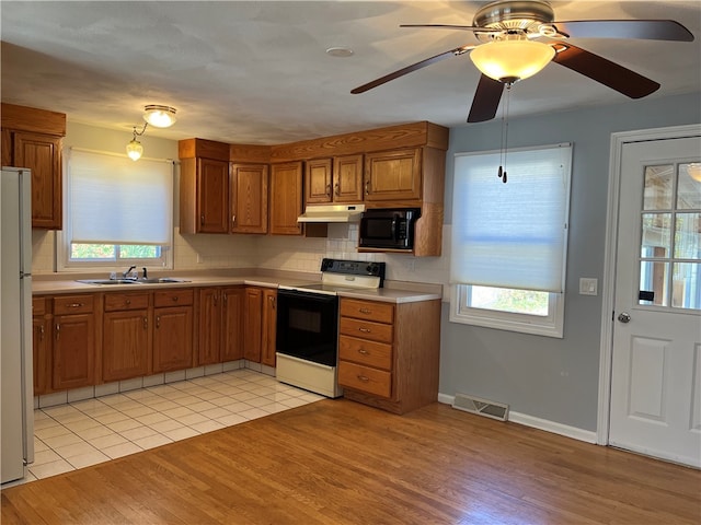 kitchen with decorative backsplash, ceiling fan, light hardwood / wood-style floors, sink, and white appliances