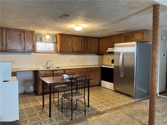 kitchen with tasteful backsplash, sink, range, a textured ceiling, and stainless steel fridge with ice dispenser