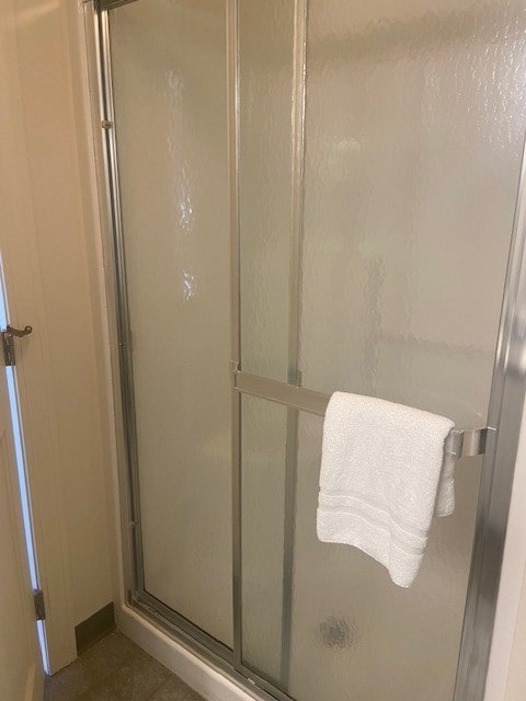 bathroom featuring an enclosed shower and tile patterned floors