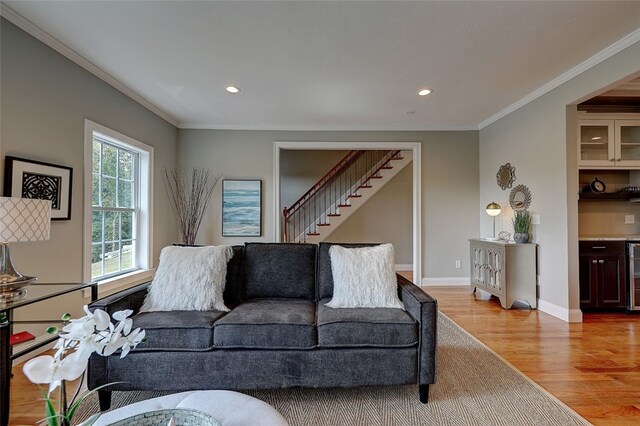 living room featuring light hardwood / wood-style flooring, beverage cooler, and crown molding